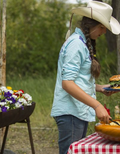 Girl in Cowboy Hat Standing Outside with Barbecue Hamburger - Lazy L&B Dude Ranch Wyoming