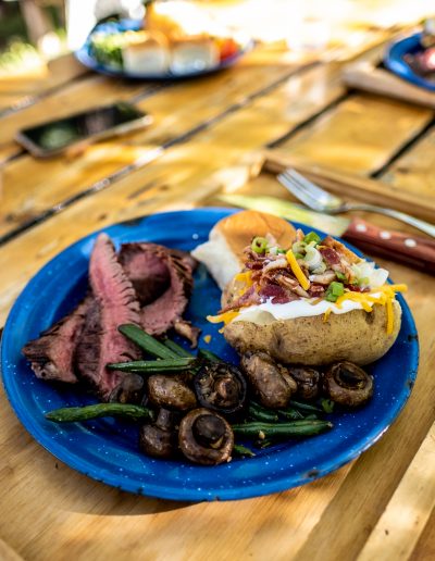 Blue camp plate with grilled steak and a loaded baked potato - Lazy L&B Dude Guest Ranch Dubois Wyoming