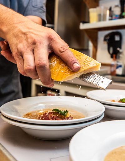 CamChef grating parmesan onto a bowl of soup - Lazy L&B Dude Ranch Wyoming